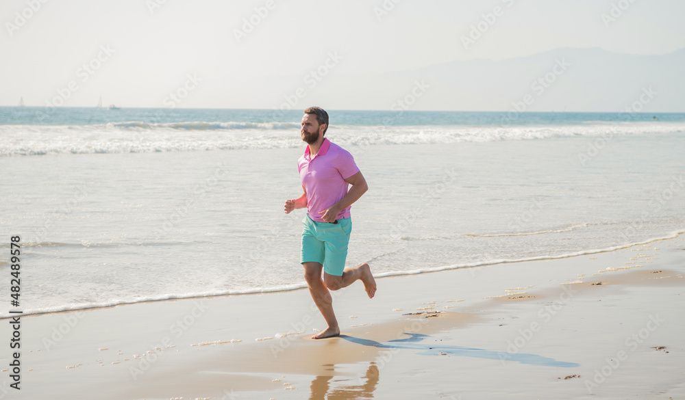 happy man runner running barefoot on summer beach, activity happy man runner running barefoot on summer beach, activity