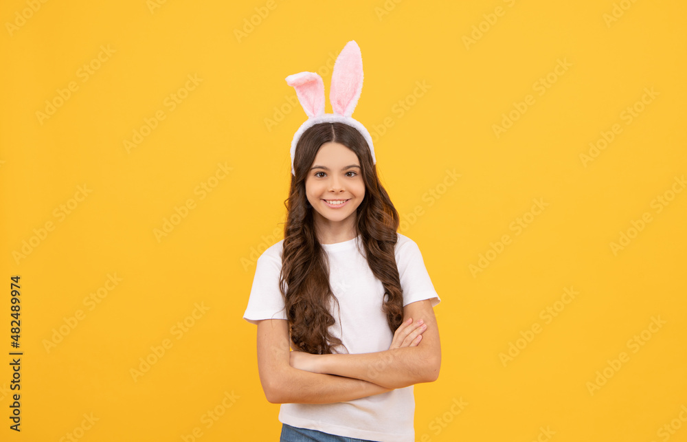 happy child in bunny ears on yellow background, easter