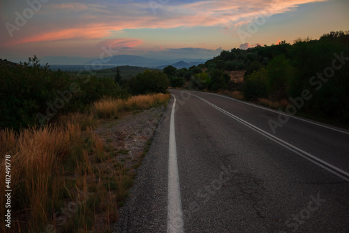 country side transportation road for car driving through land with hills twilight landscape in sunset romantic time travel style concept photography, soft focus on asphalt texture