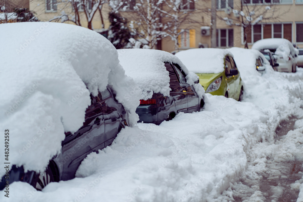 Snowfall in the city. Car covered in several inches of snow. Car almost totally buried Snowfall in the city. Car covered in several inches of snow. Car almost totally buried