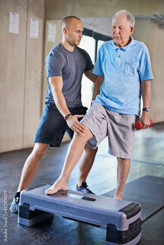 Recovery can be a long road. Cropped shot of a handsome personal trainer with a senior man.