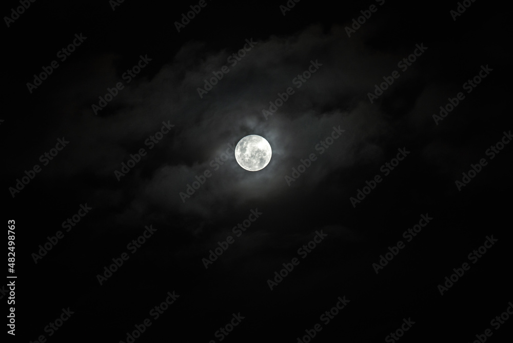 Full Moon Behind Clouds on Black Sky. Dramatic Sky. Horror Sky. Serenity Nature Background. Full Moon Behind Clouds on Black Sky. Dramatic Sky. Horror Sky. Serenity Nature Background.