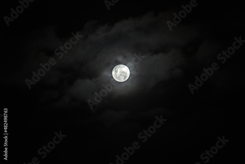 Full Moon Behind Clouds on Black Sky. Dramatic Sky. Horror Sky. Serenity Nature Background.