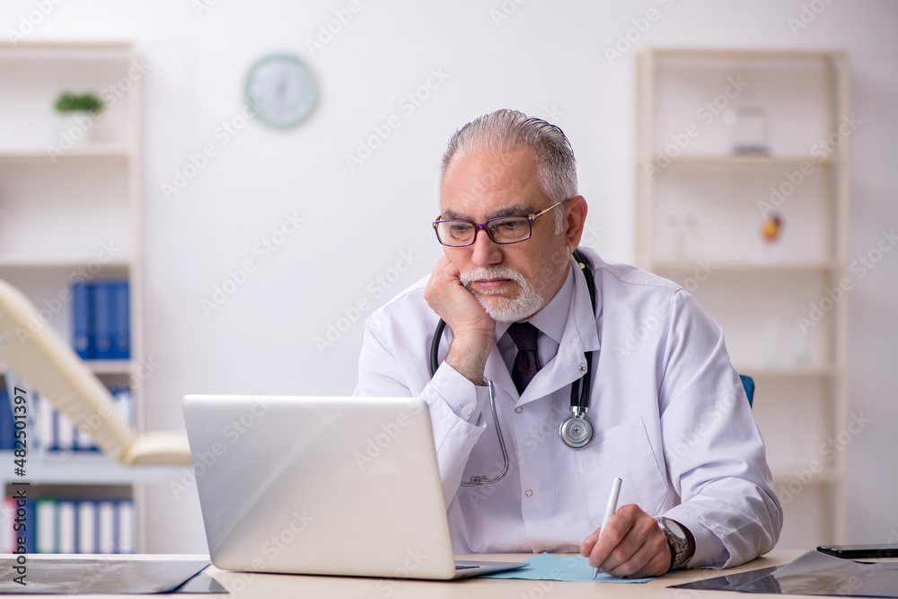 Old male doctor working at the hospital