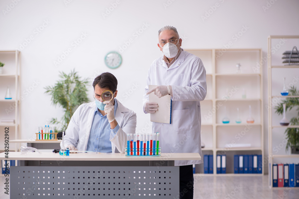 Two male chemists working at the lab during pandemic Two male chemists working at the lab during pandemic