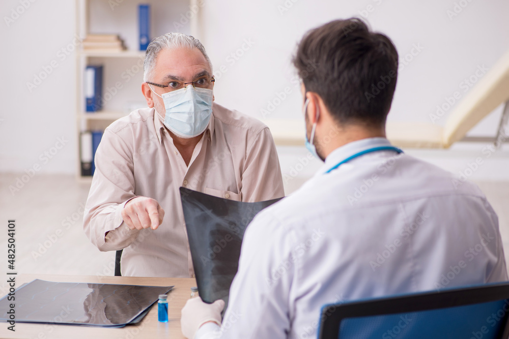 Obraz premium Old male patient visiting young male doctor radiologist during p
