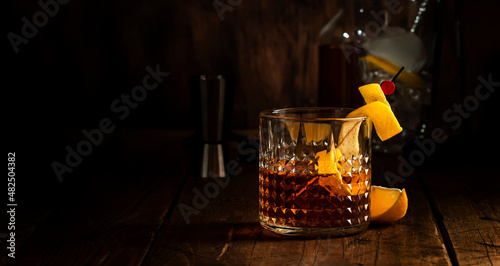 Sazerac cocktail with cognac, bourbon, absinthe, bitters, sugar and lemon zest. Old wooden bar counter background with copy space