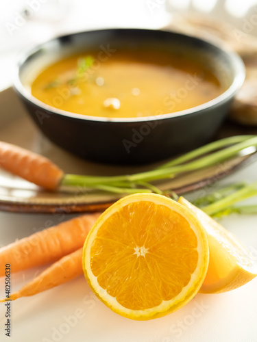 Close-up of orange and carrots, in the background the prepared cream. Healthy food concept.