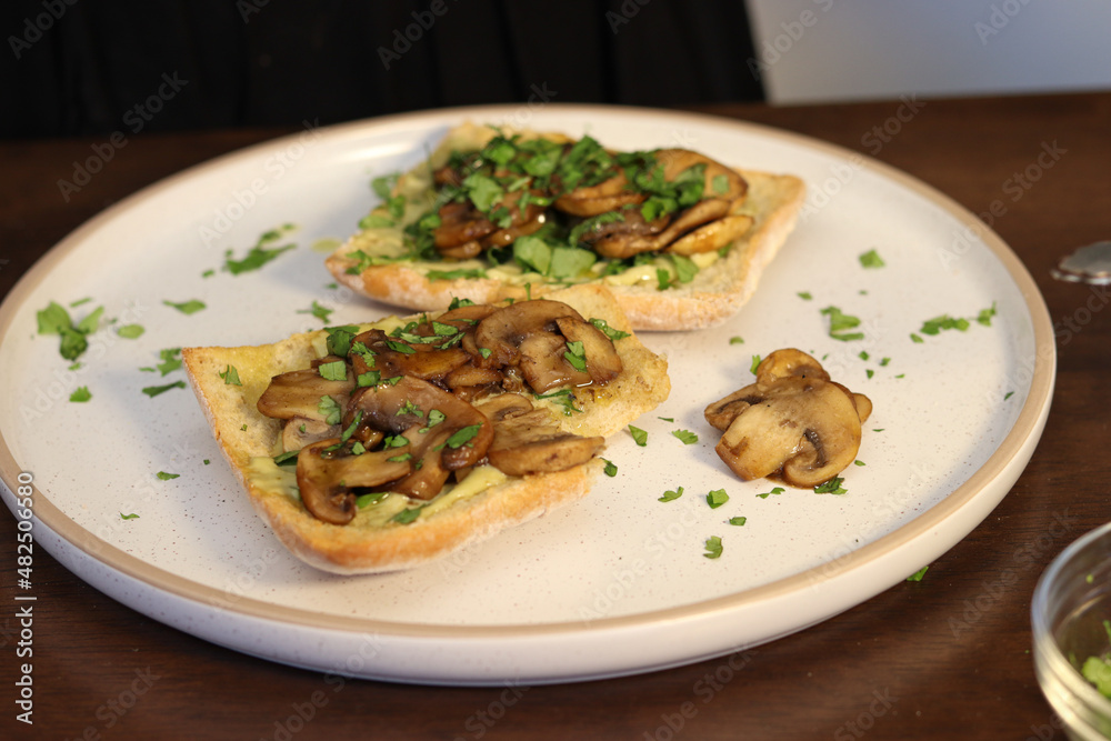 breakfast toast with chives, cilantro and mushrooms in butter on white bakery bread with olive oil