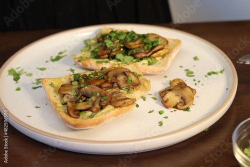 breakfast toast with chives, cilantro and mushrooms in butter on white bakery bread with olive oil