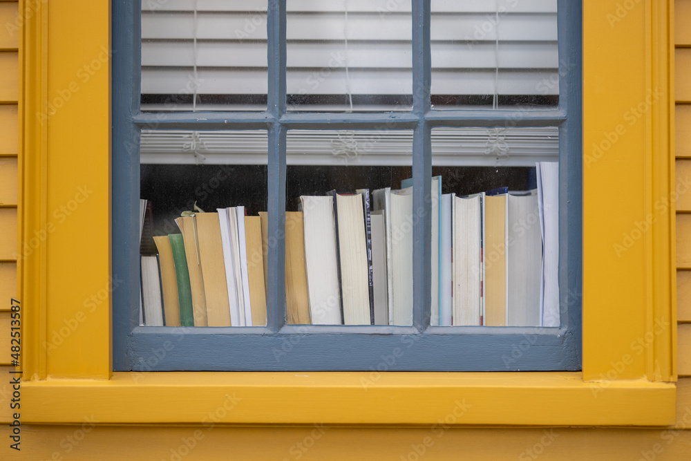 Books on window sill through closed widow Books on window sill through closed widow