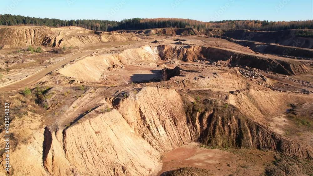 Opencast mine and mining industry concept. Flying over a drone over an open pit. Drone view of the sand pit. Aerial view of a mountain canyon with land structure after quarrying. Opencast mine and mining industry concept. Flying over a drone over an open pit. Drone view of the sand pit. Aerial view of a mountain canyon with land structure after quarrying.