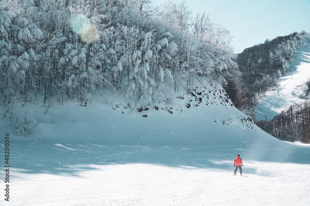 Man skiing downhill. Man in warm clothes posing while skiing. Winter season sports. Winter sports concept. Extreme sports skiing freestyle. Winter vacation on mountain.