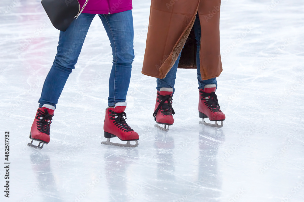feet on the skates of a person rolling on the ice rink feet on the skates of a person rolling on the ice rink
