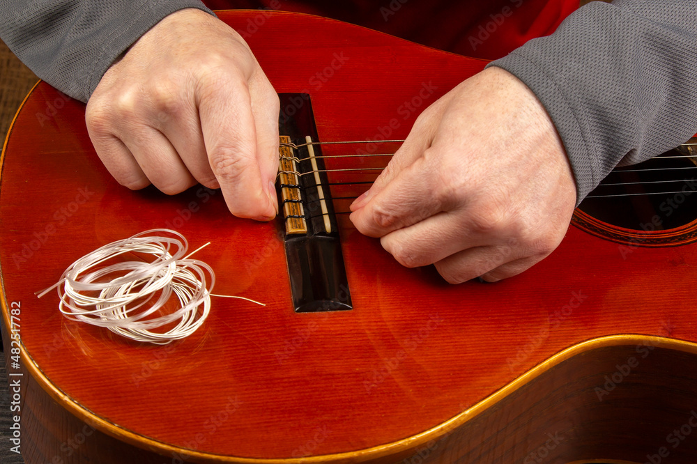 Changing nylon strings on a sixstring classical guitar. instruction