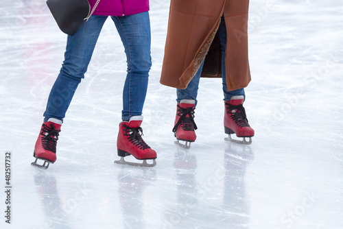 feet on the skates of a person rolling on the ice rink