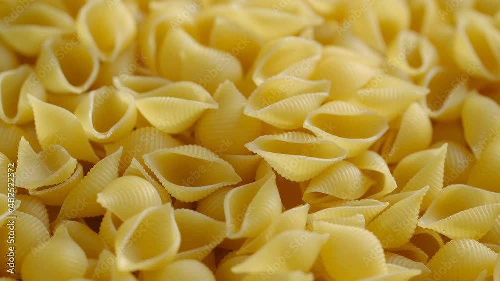 Pasta conchiglie.Pasta for food, rotation. Macaroni - Mini Conchiglie Rigate close up.Shell pasta Pasta conchiglie.Pasta for food, rotation. Macaroni - Mini Conchiglie Rigate close up.Shell pasta