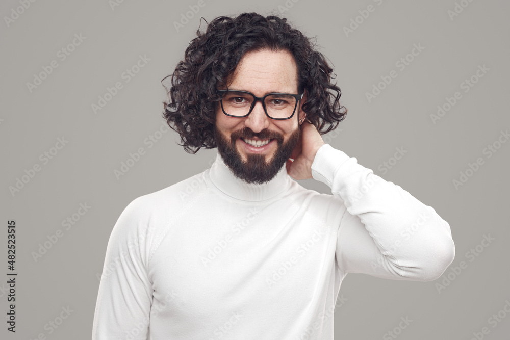 Obraz premium Smiling bearded man with curly hair in eyeglasses