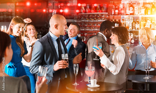 Portrait of man having a fun and talking to woman on corporate party