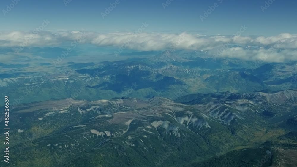 Aerial view from plane on wild terrain of Kamchatka peninsula under clouds, Russia Aerial view from plane on wild terrain of Kamchatka peninsula under clouds, Russia