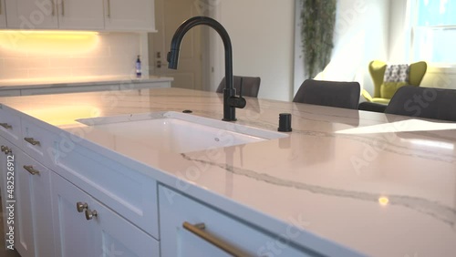 White Granite Island Top with a Modern Faucet in an Open Concept Home photo
