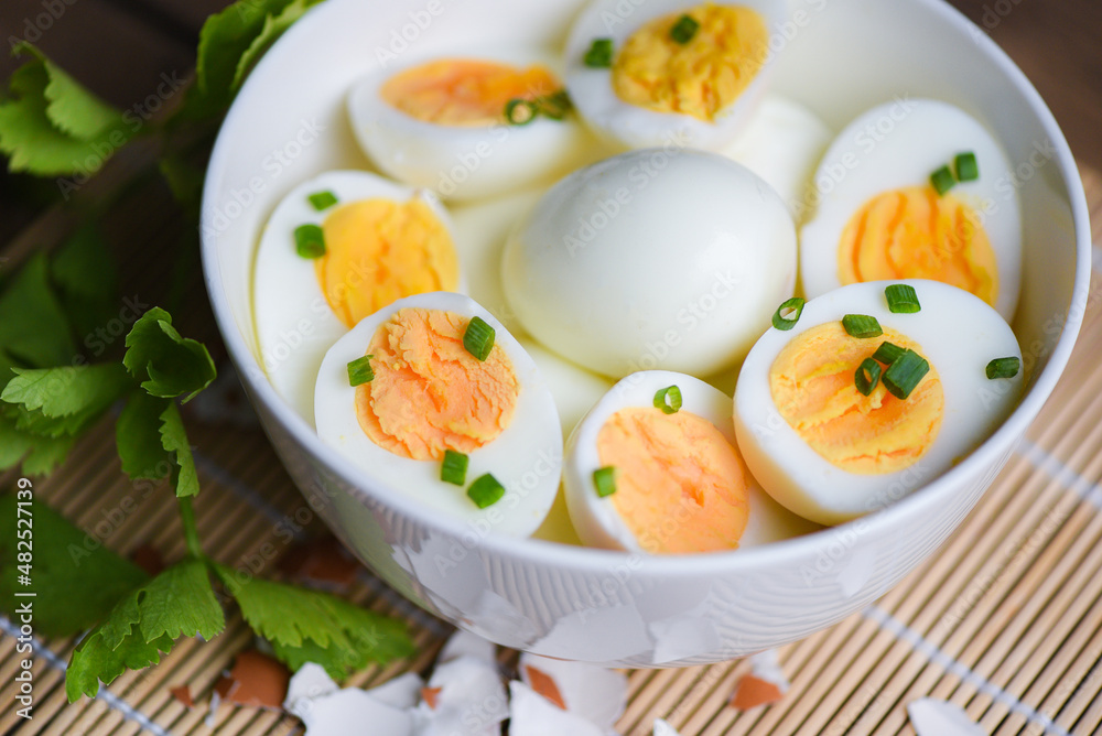 Eggs breakfast, fresh eggs menu food boiled eggs in a bowl decorated with leaves chopped fresh green onions and celery on wooden background, cut in half egg yolks for cooking healthy eating Eggs breakfast, fresh eggs menu food boiled eggs in a bowl decorated with leaves chopped fresh green onions and celery on wooden background, cut in half egg yolks for cooking healthy eating