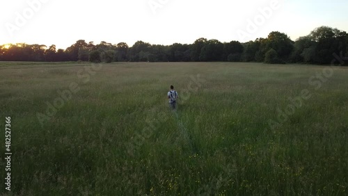 Wallpaper Mural Man hiking through a field, drone pull away shot revealing the beautiful area the man is calmly walking through Torontodigital.ca