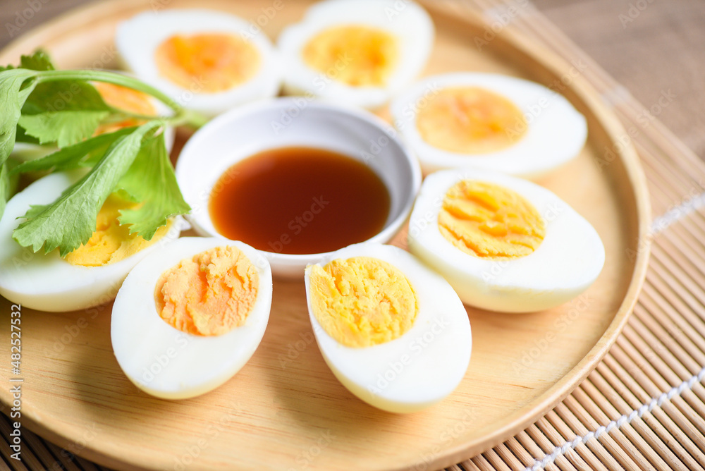 Eggs breakfast, fresh eggs menu food boiled eggs in a wooden plate decorated with leaves green celery and fish sauce on wooden background, cut in half egg yolks for cooking healthy eating Eggs breakfast, fresh eggs menu food boiled eggs in a wooden plate decorated with leaves green celery and fish sauce on wooden background, cut in half egg yolks for cooking healthy eating