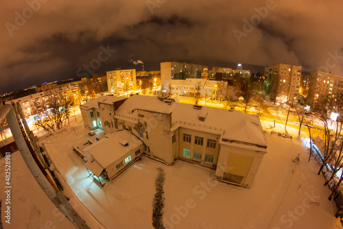 night city view with yellow lanterns in winter. streets from above with snow