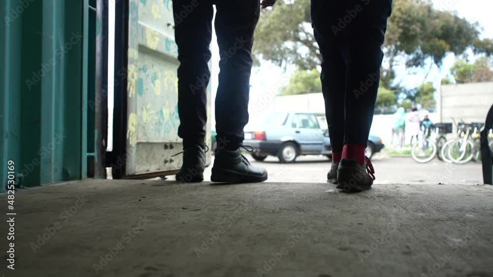 Two boys leave a shipping container. The container is used as an office and the boys leave to move outside. Two boys leave a shipping container. The container is used as an office and the boys leave to move outside.