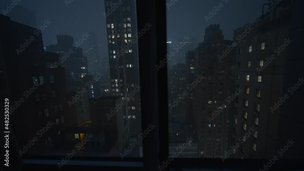Manhattan, New York City view through window at night during a thunderstorm with lightning and rain