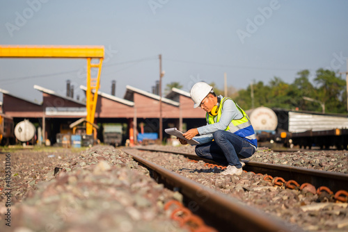 Engineer under inspection and checking construction process railway locomotive repair plant, Engineer man in waistcoats and hardhats and with documents in a railway depot