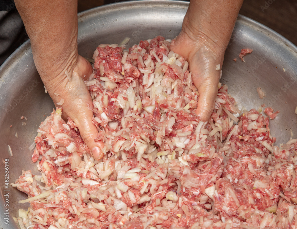 Hand stirring minced meat with onions