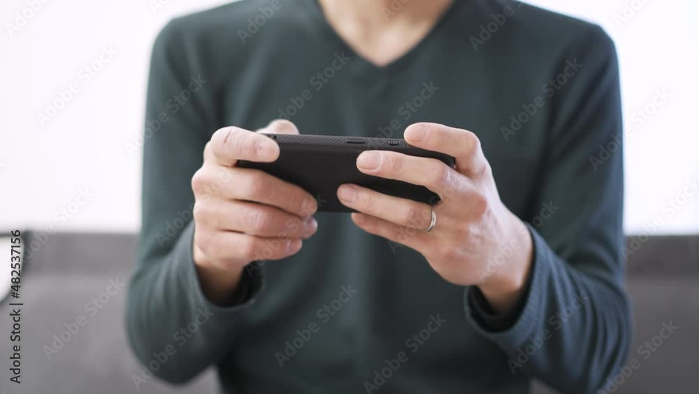 スマートフォンでゲームをするアジア人の男性 スマートフォンでゲームをするアジア人の男性