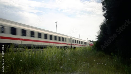 white train moving by at high speed toward a mountain photo