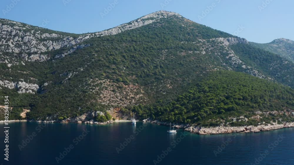 Mountainscape In Idyllic Ocean With Ship Anchored At Hidden Cove In Peljesac, Croatia. Aerial Wide Mountainscape In Idyllic Ocean With Ship Anchored At Hidden Cove In Peljesac, Croatia. Aerial Wide
