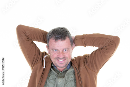 Handsome middle aged man in studio portrait with hands arms on head on white wall background