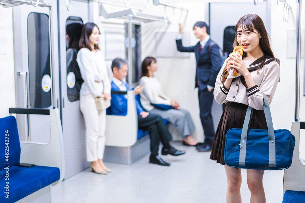 電車でパンを食べる学生 電車でパンを食べる学生
