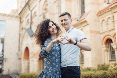 Fotografía Young couple in love form a heart with their fingers, showing their love