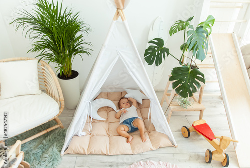 Fotografie Little baby girl sleeping in a wigwam at home