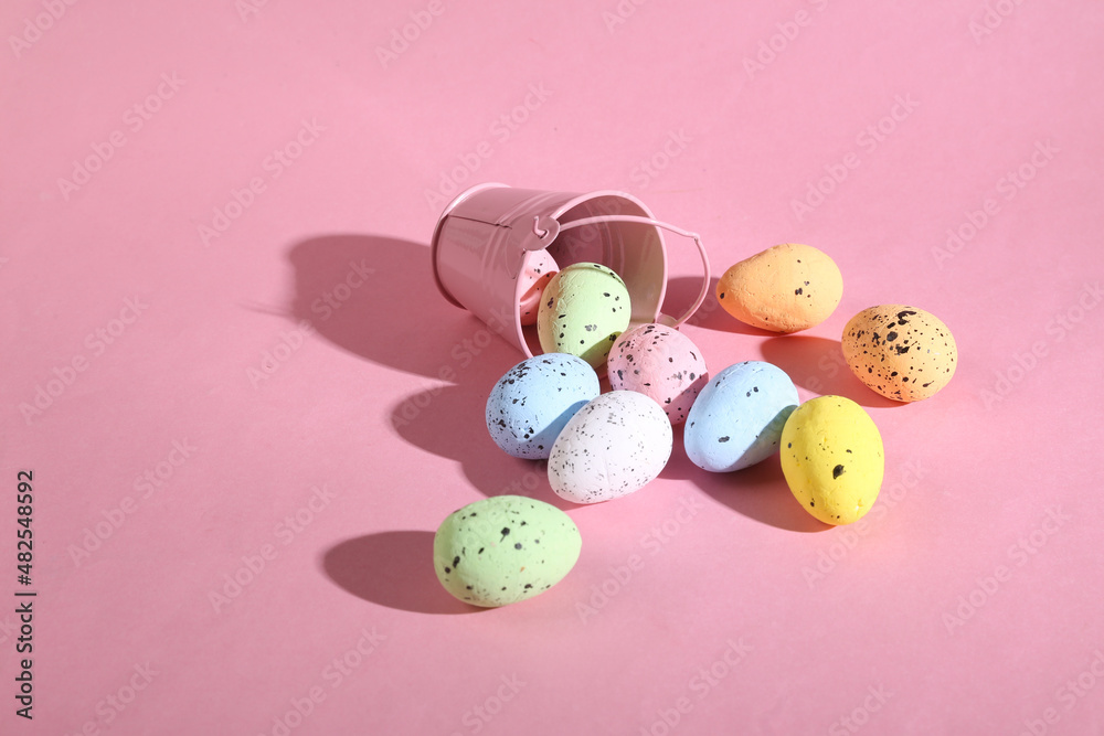 Mini bucket with colored Easter eggs on pink background. Easter minimal concept. Creative Happy Easter, spring layout.