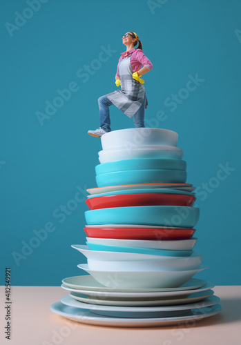 Proud woman standing on a pile of clean dishes photo