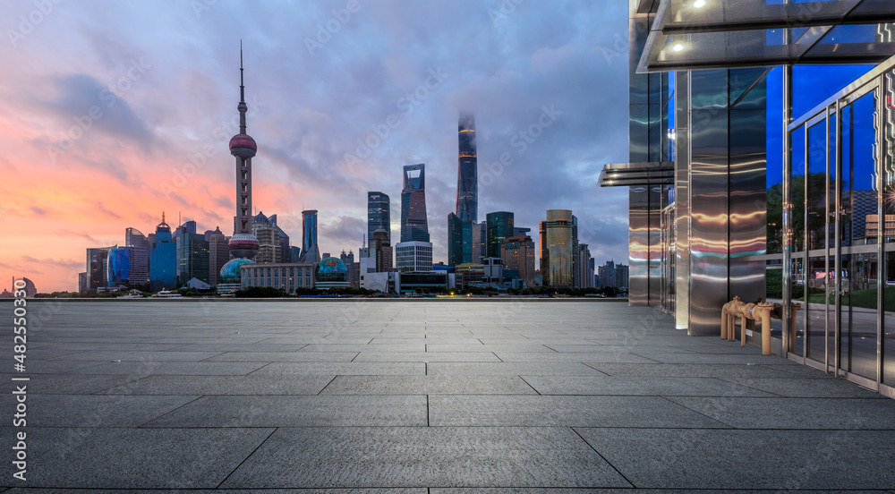 Empty square floor and city skyline with modern commercial buildings at sunrise in Shanghai, China. Empty square floor and city skyline with modern commercial buildings at sunrise in Shanghai, China.