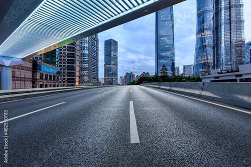Empty asphalt road and city skyline with modern commercial buildings in Shanghai, China.