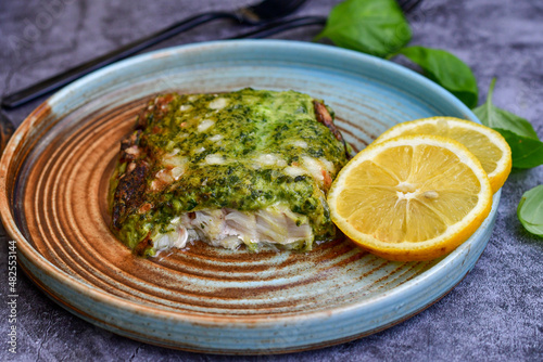 Fish bake refined with spinach and gorgonzola cheese crust.White Code fish fillet stuffed with broccoli and creamy Alfredo sauce . Healthy food, delicious homemade italian lunch .