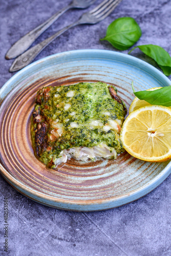 Fish bake refined with  spinach and gorgonzola cheese crust.White Code fish fillet stuffed  with broccoli  and  creamy Alfredo  sauce . Healthy food, delicious homemade italian  lunch . photo