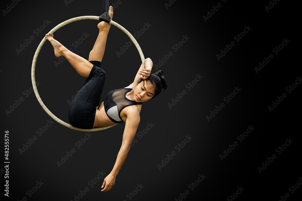 Young Asian gymnast woman doing gymnastics performance on aerial hoop in  fitness gym. Female acrobat posing on aerial ring. Stock Photo | Adobe Stock