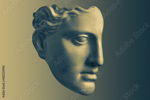 Bronze color gypsum copy ancient statue Diana head goddess of nature and hunting for artists on brass background. Profile. Plaster sculpture of woman face. Template art design dj, fashion, poster.