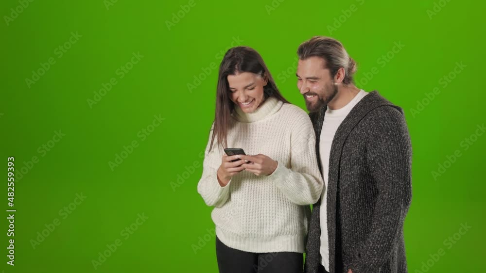 Happy couple reading something funny on modern smartphone Happy couple reading something funny on modern smartphone