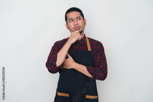 Adult Asian man wearing apron showing thinking gesture photo